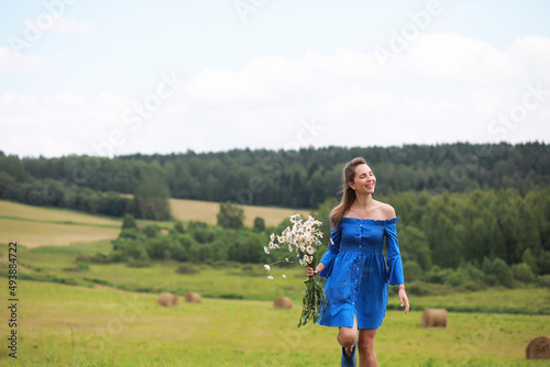 Young cute girl run in a field at sunset