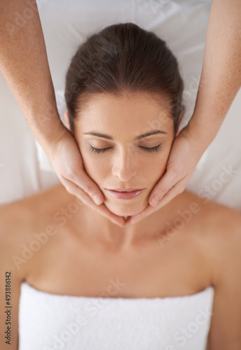 Beauty treatment. Shot of a young woman receiving a face massage.