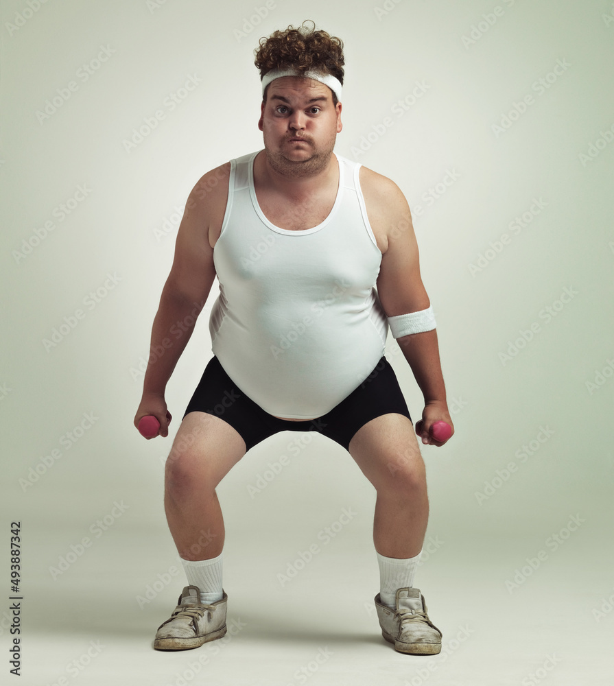 Deep squat. Portrait of an overweight man squatting and lifting dumbbells. Deep squat. Portrait of an overweight man squatting and lifting dumbbells.