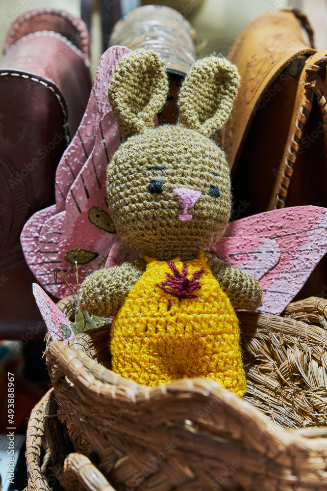 Adorable stuffed animal in the shape of a bunny on a basket for Easter concept