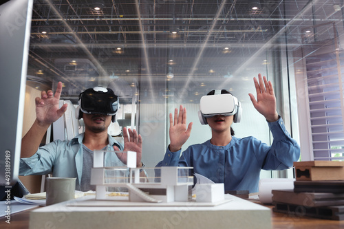 Architects and Engineer people wearing virtual reality headsets for work with virtual reality modeling software applications. Use Virtual Reality Modeling and BIM Technology in the Building complete.