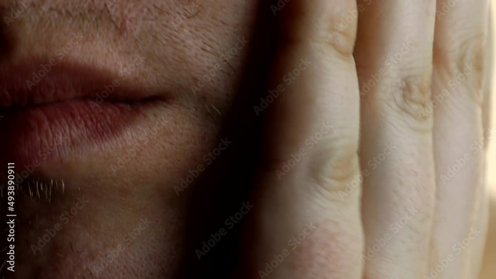An unshaven guy checks his stubble with his hand before shaving. An unshaven guy checks his stubble with his hand before shaving.