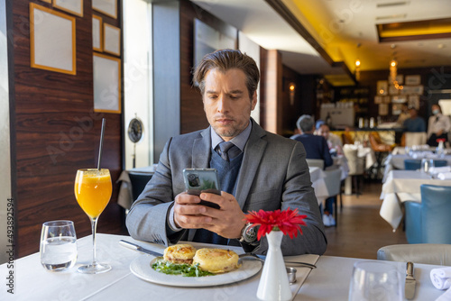 Handsome businessman using smartphone in the restaurant