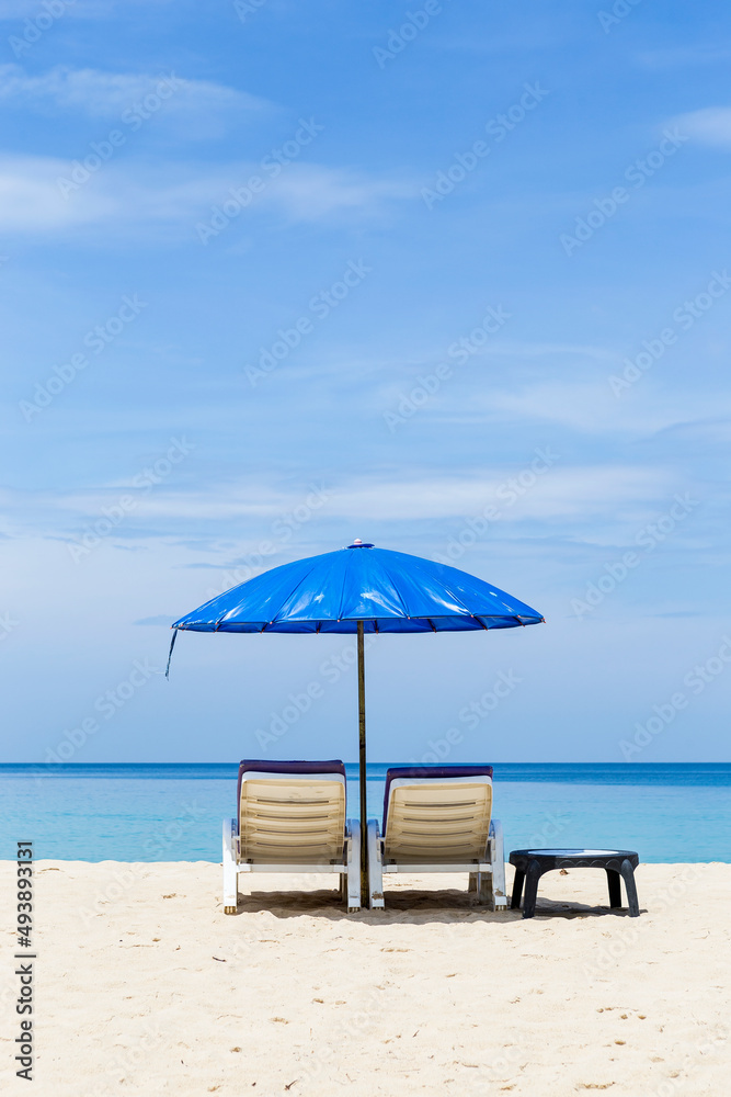 Plastic beach bench under blue umbrella over blue sea view, summer holiday destination, tourist attraction in south of Thailand, relax by the sea