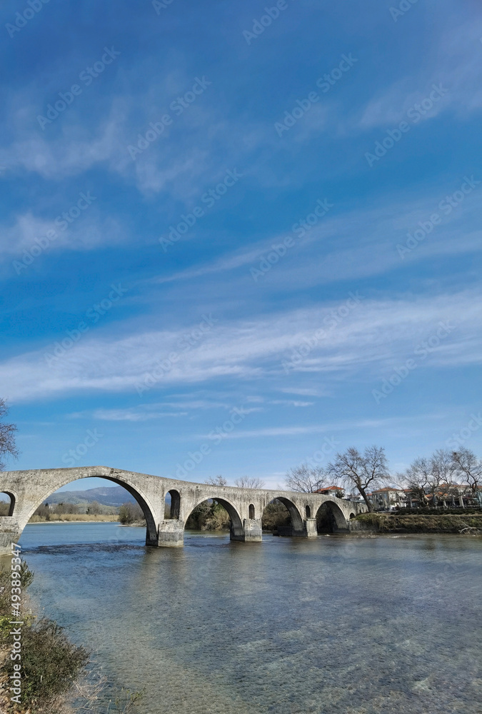 Fototapeta premium arta city old arched bridge of stones through arahthos river greece