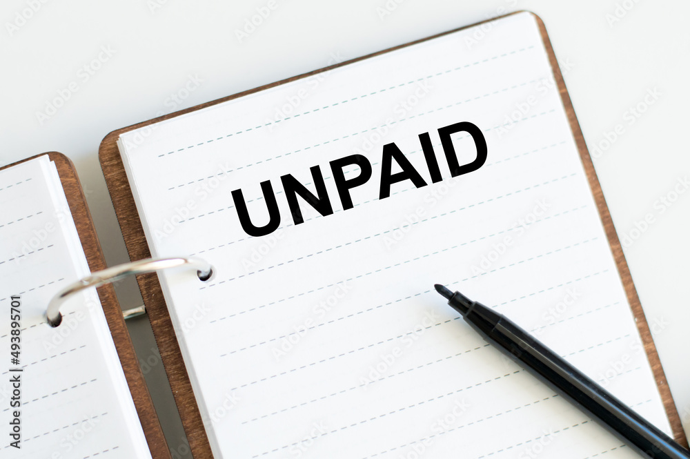 Text Unpaid on a notepad on the table. Business concept.