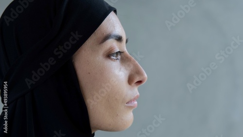 Profile of an Arab woman with beautiful features. Portrait of a Muslim woman in a black hijab. Muslim women in the media industry, actresses playing the role of oriental women.