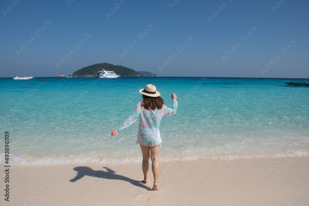 Tourist woman relax on the beach. Happy island lifestyle. White sand, blue cloudy sky and crystal sea of tropical beach. Vacation at similan islands in Andaman sea at Phang Nga province near Phuket 