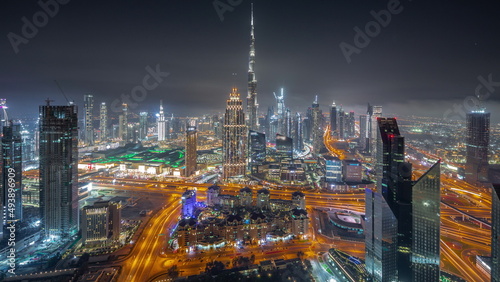 Aerial view of tallest towers in Dubai Downtown skyline and highway all night timelapse.