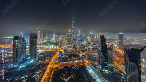 Aerial panorama of tallest towers in Dubai Downtown skyline and highway night timelapse.