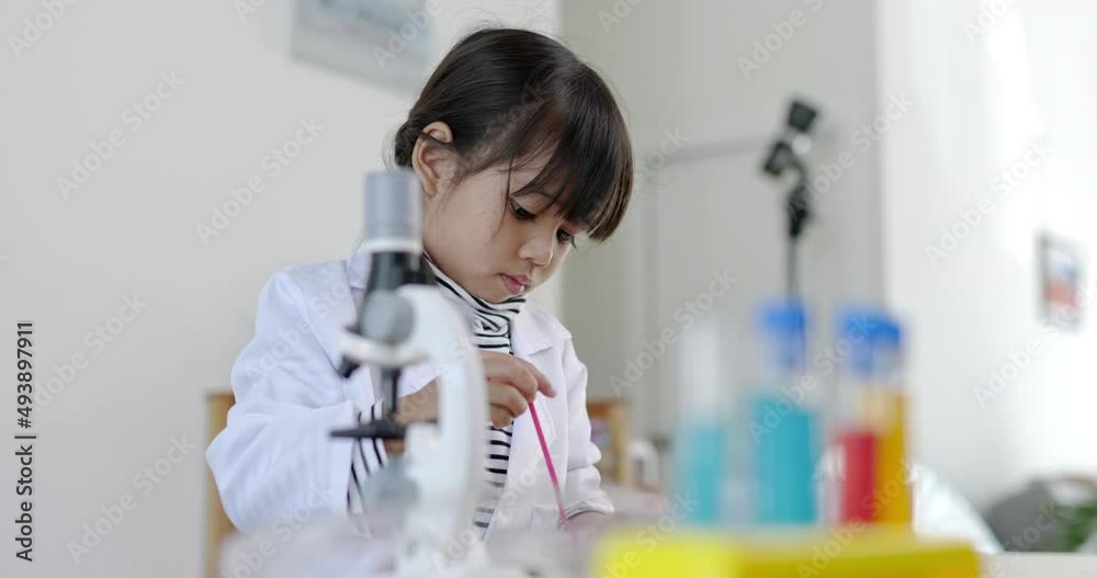 Asian siblings wearing coat using the device for experimenting with liquids. while studying science chemistry with exciting Asian siblings wearing coat using the device for experimenting with liquids. while studying science chemistry with exciting