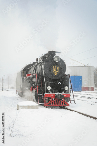 Vintage black steam locomotive. Old Soviet steam train in the depot. Space for text. Background with a steam train in the wintertime. New Year express.