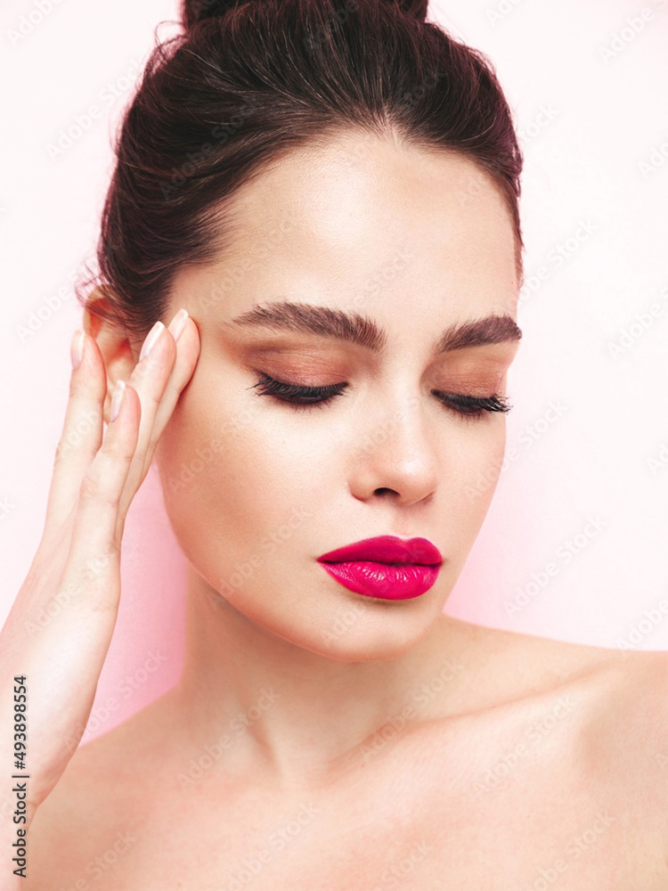 Fashion beauty portrait of young brunette woman with evening stylish makeup and perfect clean skin. Sexy model with hair in a bun posing in studio. With pink bright natural lips. Isolated on white Fashion beauty portrait of young brunette woman with evening stylish makeup and perfect clean skin. Sexy model with hair in a bun posing in studio. With pink bright natural lips. Isolated on white