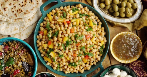 Chickpeas with vegetables and herbs. Traditional vegan dishes on the table, dates, cheese sauces photo