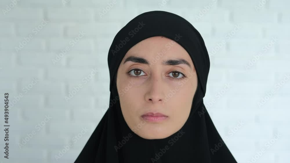 Portrait of a Muslim woman in a black hijab who is looking at the camera. The attitude of the world towards the Muslim religion, the right to worship is equal for all. Woman in Islam. Portrait of a Muslim woman in a black hijab who is looking at the camera. The attitude of the world towards the Muslim religion, the right to worship is equal for all. Woman in Islam.