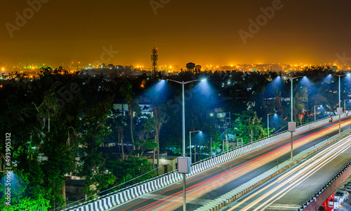 Night highway with car traffic, lights trails and city lights when long exposure, soft focus
 photo