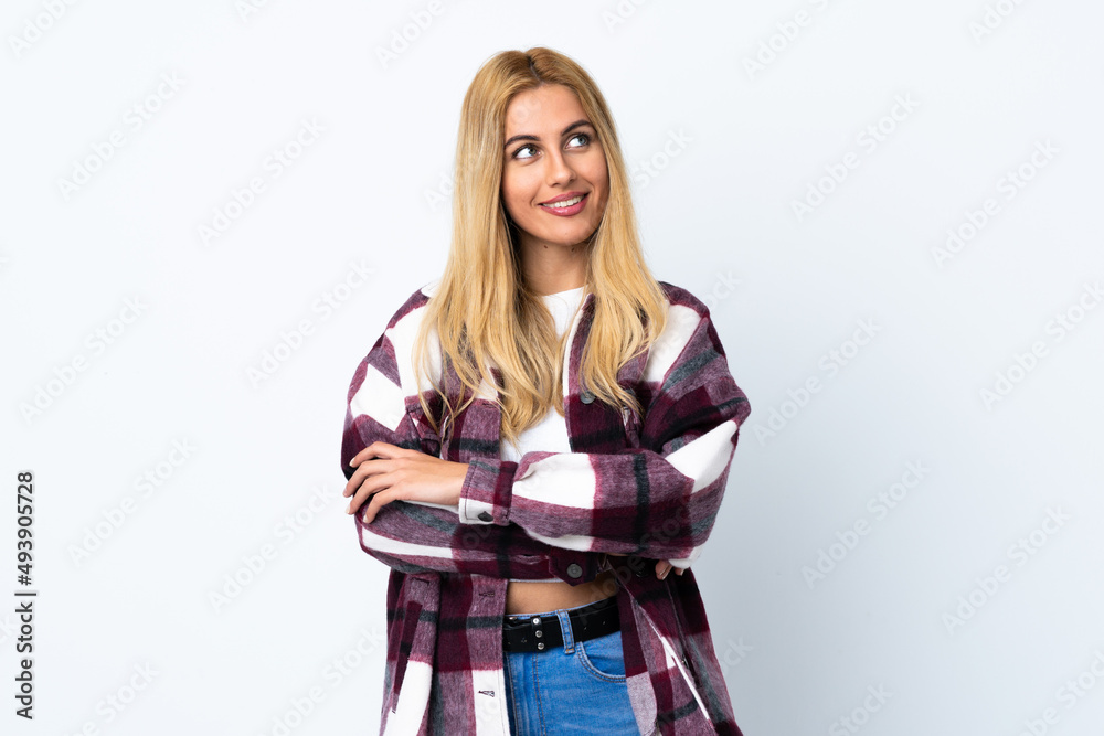 Young Uruguayan blonde woman over isolated white background looking up while smiling