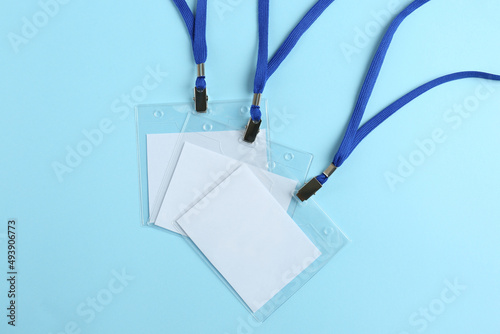 Blank badges on light blue background, flat lay. Mockup for design