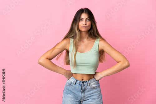 Young caucasian woman isolated on pink background angry