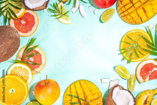 Fototapeta Naklejka Na Ścianę i Meble -  Summer fruits background. Various tropical fruits on turquoise background - mango, coconut, apples, avocado, lemon, orange, grapefruit, pineapple, with palm leaves. Colorful frame, banner flatlay