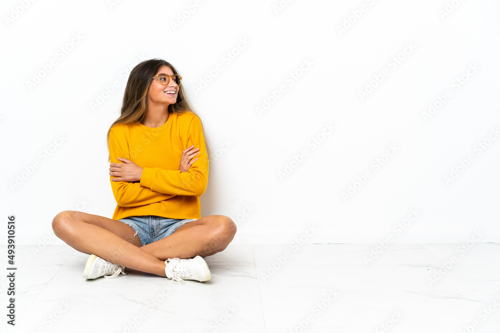 Young woman sitting on the floor isolated on white background happy and smiling Young woman sitting on the floor isolated on white background happy and smiling