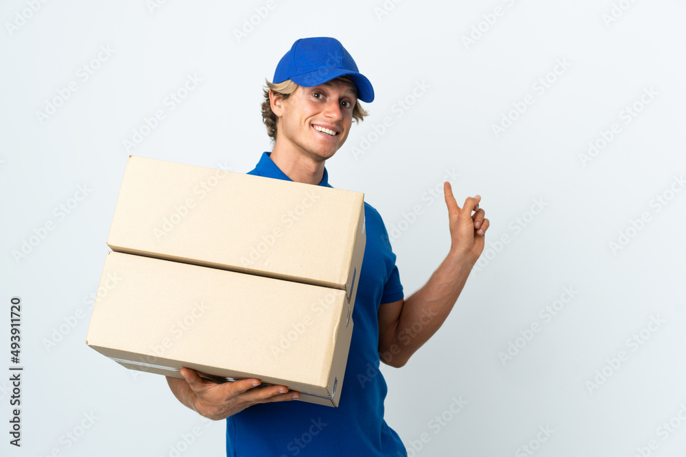 Delivery man over isolated white background pointing back Delivery man over isolated white background pointing back