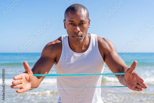 Sportsman with resistance band practicing on sunny day