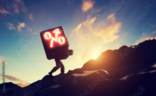 Fotografia Man carrying heavy stone with growing interest rate symbol