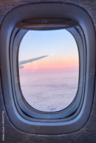 View from airplane window at sunset with cloudy sky