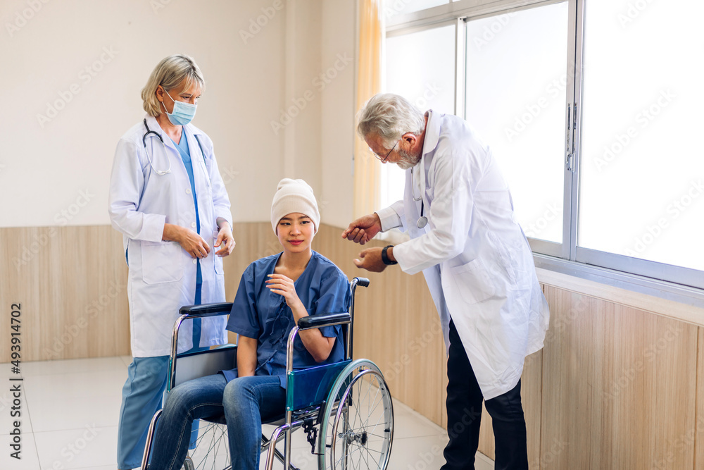 Professional medical doctor team with stethoscope in uniform discussing with patient woman with cancer cover head with headscarf of chemotherapy cancer in hospital.health care concept Professional medical doctor team with stethoscope in uniform discussing with patient woman with cancer cover head with headscarf of chemotherapy cancer in hospital.health care concept