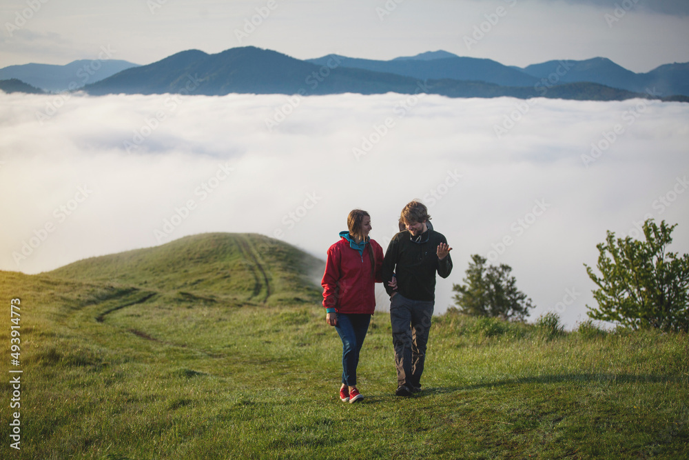 Young Couple in Love Walks in Amazing Carpathian Misty Mountain Scenery