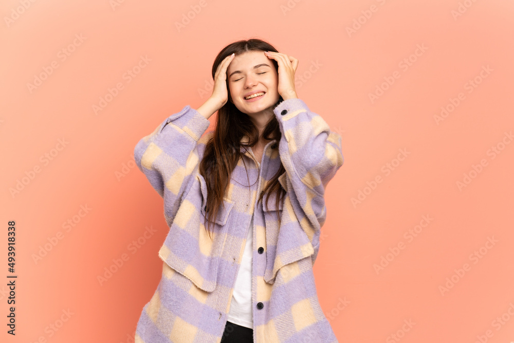 Young Ukrainian girl isolated on pink background laughing