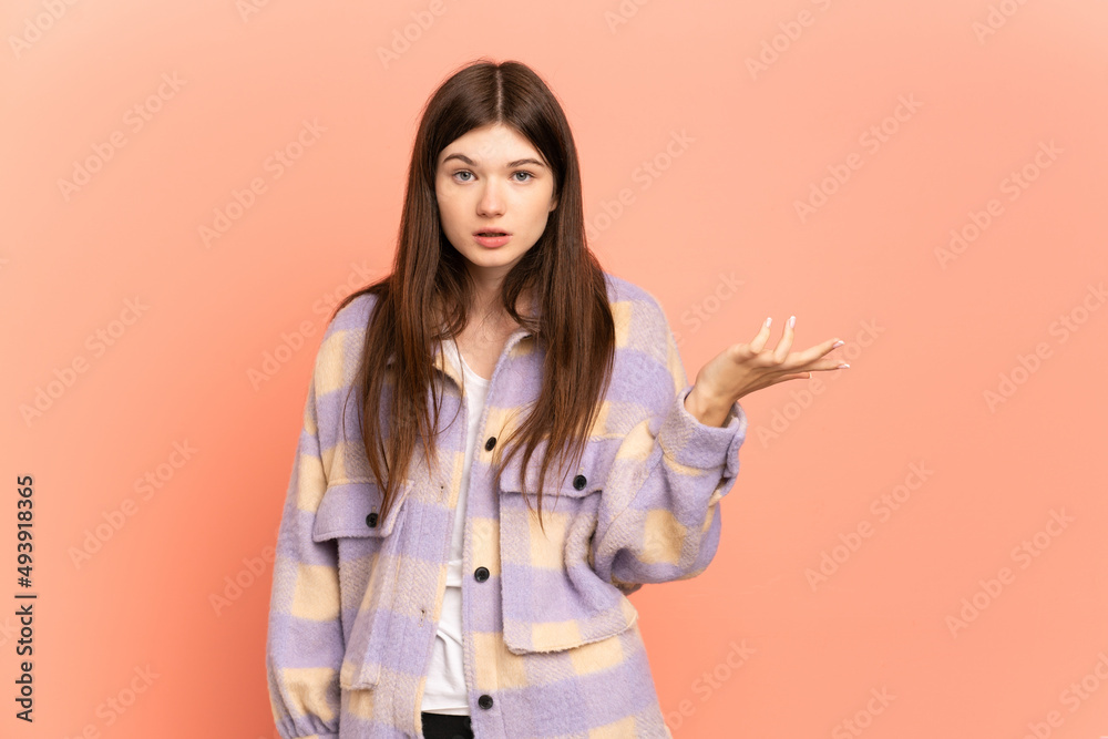 Young Ukrainian girl isolated on pink background making doubts gesture Young Ukrainian girl isolated on pink background making doubts gesture