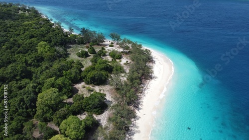 Stunning curved white sandy beach with two tone turquoise and deep blue ocean on remote tropical Jaco Island, Timor Leste