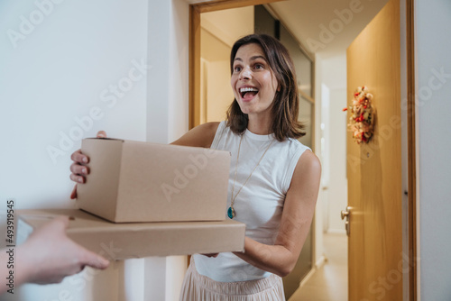 Surprise woman receiving packages from delivery person at door