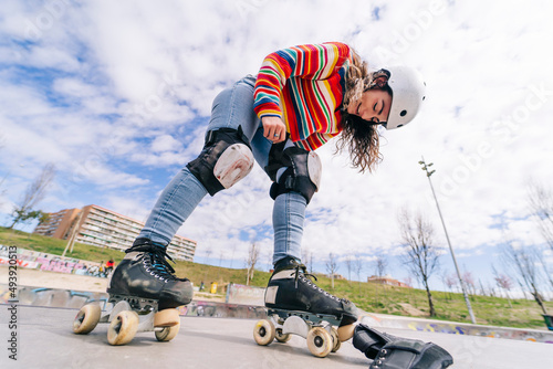 Smiling woman roller skating wearing kneepads