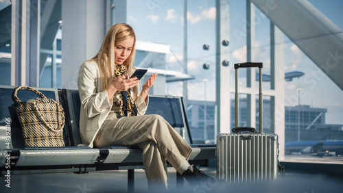 Airport Terminal: Woman Waits for Flight, Uses Smartphone, Receives Shockingly Bad News, Starts Crying. Upset, Sad, and Dissappointed Person Sitting in a Boarding Lounge of Airline Hub. photo