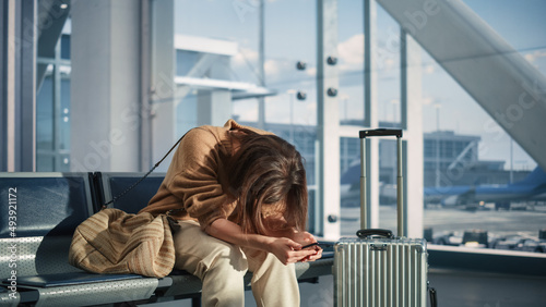 Obraz na płótnie Airport Terminal: Woman Waits for Flight, Uses Smartphone, Receives Bad News, Starts Crying