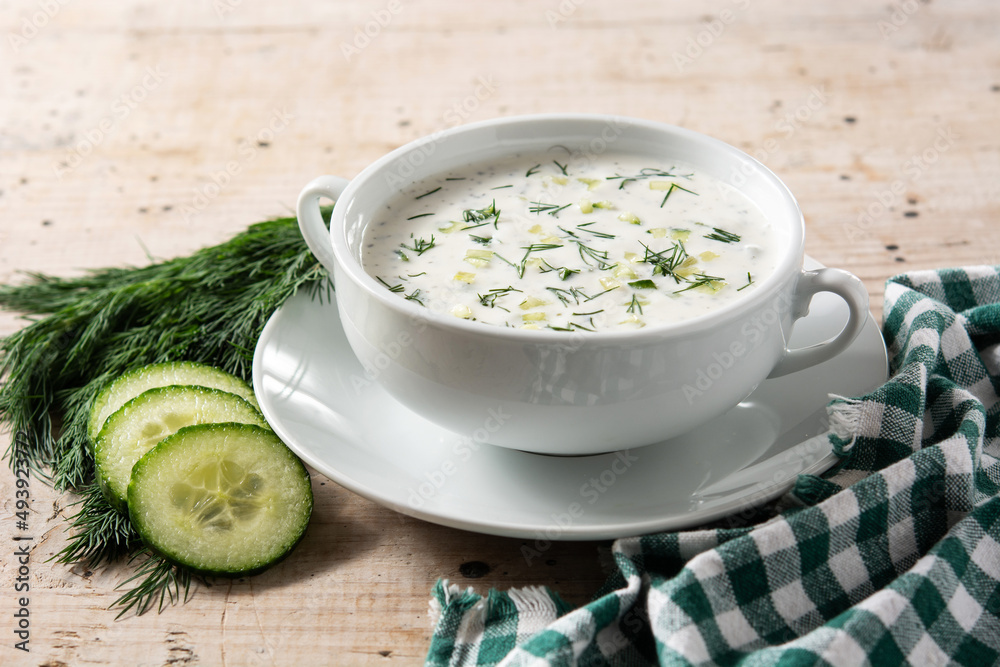 Bulgarian tarator sour milk soup in bowl on wooden table Bulgarian tarator sour milk soup in bowl on wooden table