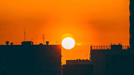 Fototapete Orange Sonnenaufgang über Wohnhäusern der Stadt  © VeNN