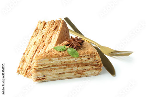 Pieces of honey cake and cutlery isolated on white background