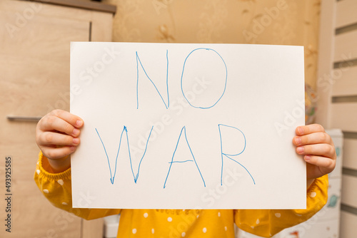 child holding a sign with the words no to war