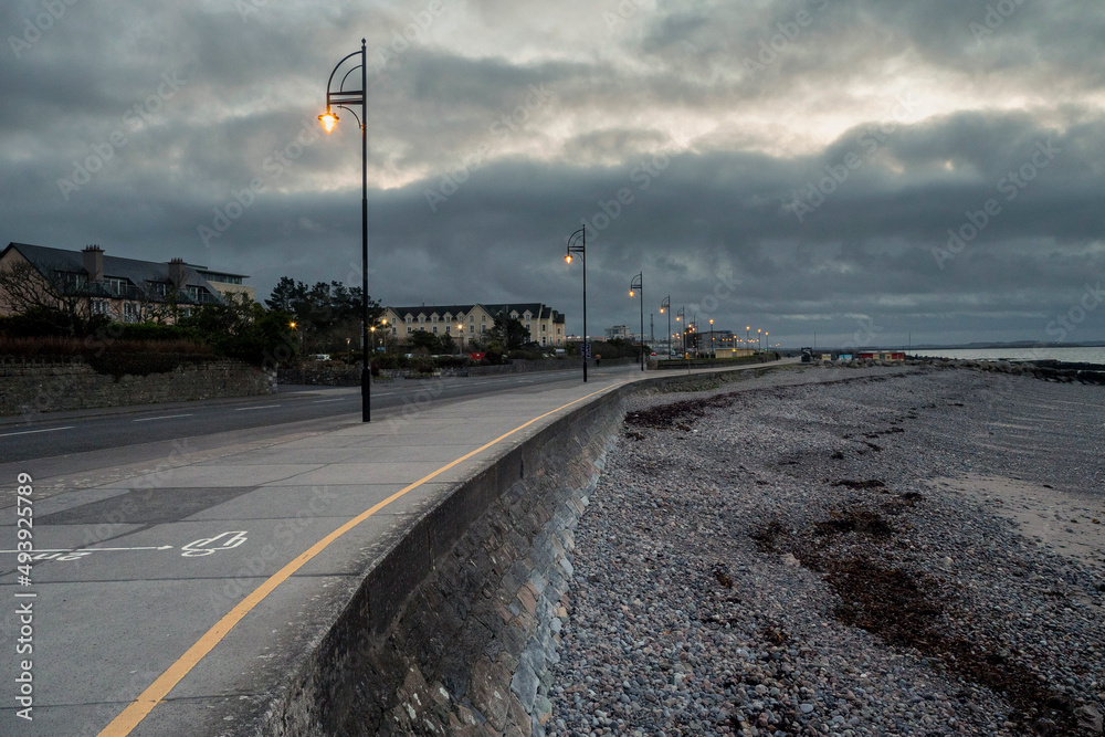 Empty Salthill promenade at dusk. Cool tone. Galway city, Ireland. Nobody. City lights glow in the dark