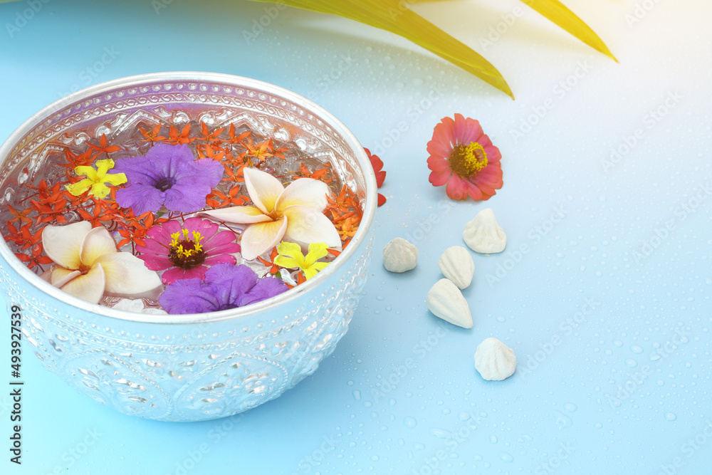 Thai songkran festival - Silver bowl with colorful flower and chalk powder on blue Thai songkran festival - Silver bowl with colorful flower and chalk powder on blue
