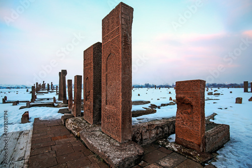 Historical Ahlat Seljuk Square Cemetery with islamic tombstones during winter under snow