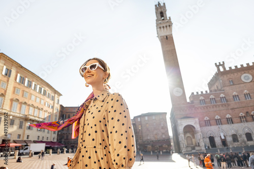 Portrait of a woman on background of town hall of Siena city  traveling famous places in Tuscany. Concept of visiting italian landmarks and style