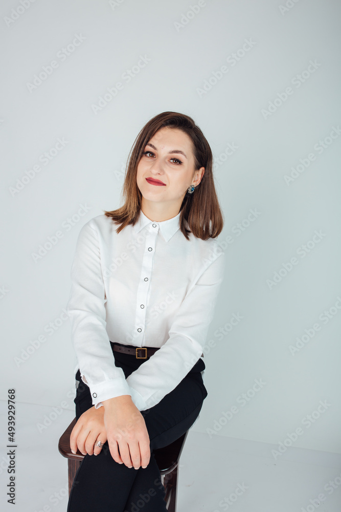 Studio shot of a woman in a white blouse and black pants on a white background. Shooting in business style. Photo for resume Studio shot of a woman in a white blouse and black pants on a white background. Shooting in business style. Photo for resume