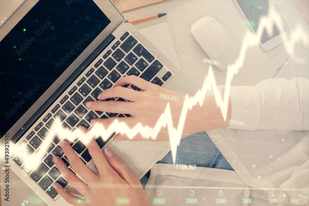 Double exposure of woman hands working on computer and forex chart hologram drawing. Top View. Financial analysis concept. Double exposure of woman hands working on computer and forex chart hologram drawing. Top View. Financial analysis concept.