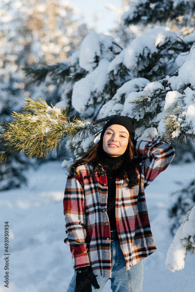 Smiling woman walks in forest in sunny winter day. Smiling woman walks in forest in sunny winter day.