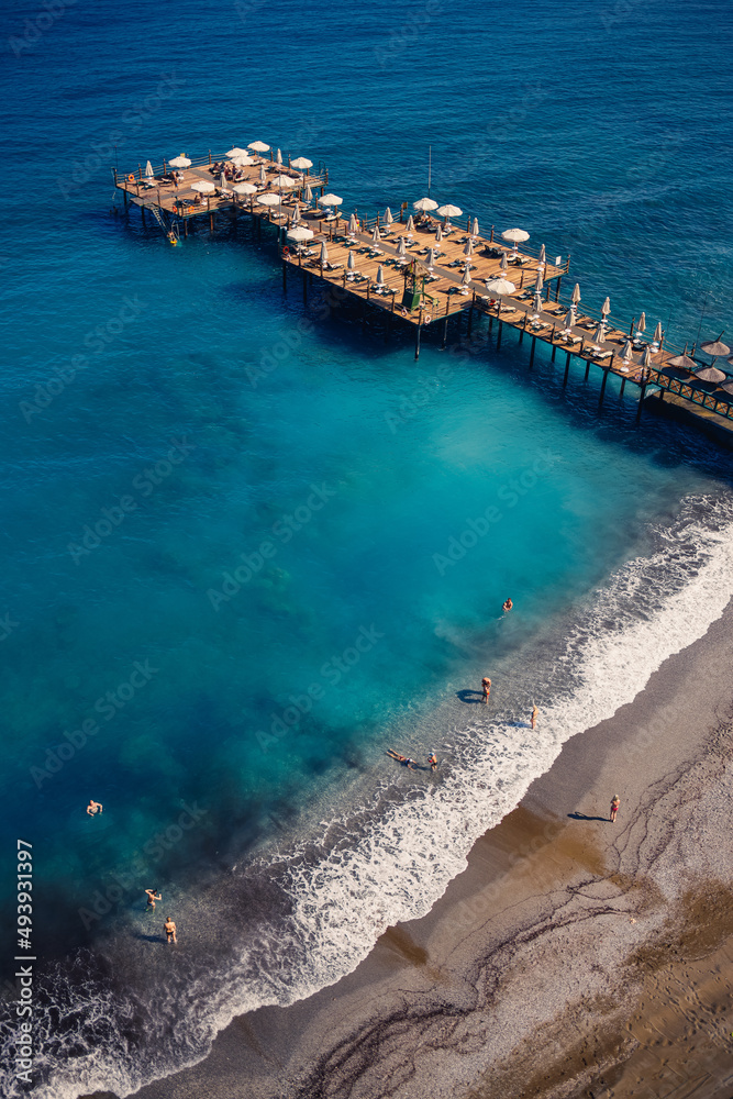 Aerial view of the beach and the mediterranean sea, beautiful clear sea water on a warm sunny day. The concept of rest in a warm country